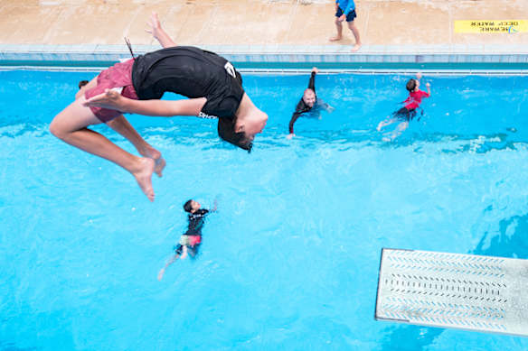 Harry Ward does a backflip off the diving board at Canberra Olympic Pool.