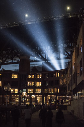 Protestors shining light onto the sails of the Opera House from under the southern pylon at the Overseas Shipping Terminal.