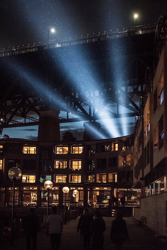 Protestors shining light onto the sails of the Opera House from under the southern pylon at the Overseas Shipping Terminal.