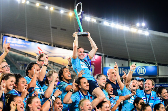 History: Ash Hewson holds the trophy aloft as NSW players celebrate their Super W title.