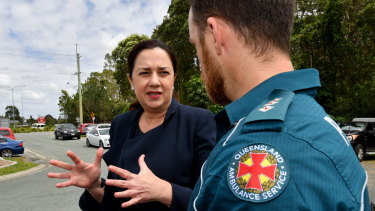 Premier Annastacia Palaszczuk speaking to a paramedic in the new Logan electorate of Macalister on Wednesday.