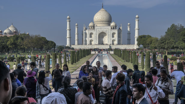 Tourists takes photos in front of the Taj Mahal, in Agra, India.