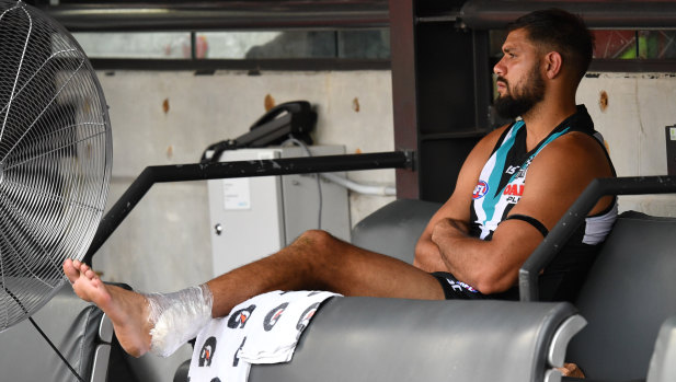 An injured Patrick Ryder sits on the bench at Adelaide Oval.
