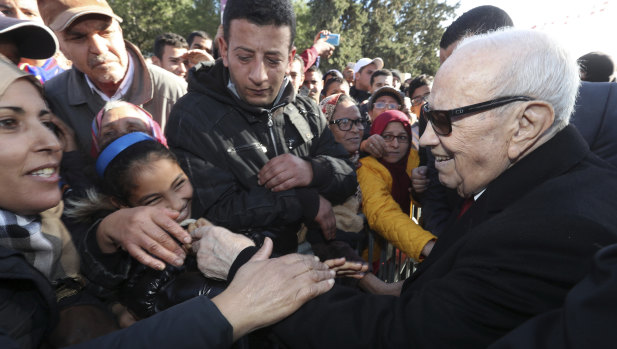 Tunisian President Beji Caid Essebsi shake hands with bystanders as he arrives for a event in Tunis, Tunisia, on Sunday, January 14.