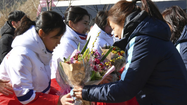 North Korean ice hockey players are greeted by their South Korean counterparts.