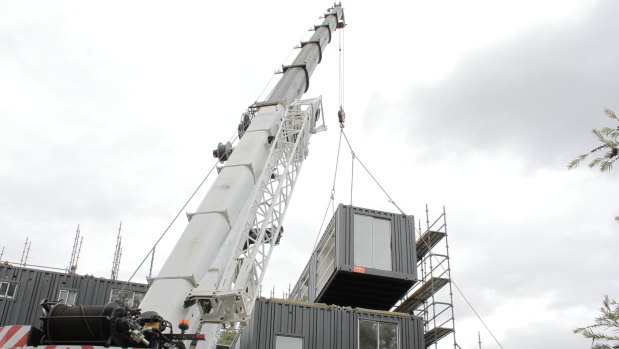 A crane lifts a module into place at Guildford.