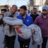 Relatives carry the body of 13-year-old Seraje Ebrahim, who was killed in an Israeli strike on a drinking water distribution point on Sunday.