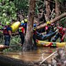 Firefighters from Ciudad Acuña, Mexico, load a body into a raft as they prepare for a water recovery along the Guadalupe River days after a flash flood swept through the area.