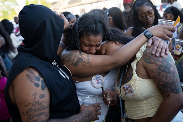 Perezia Solomon, Ariel Brown and Bri Wilson embrace as dozens gather for a balloon release in North Lawndale in honor of Zahrie Walls, who tragically died in Lake Michigan.