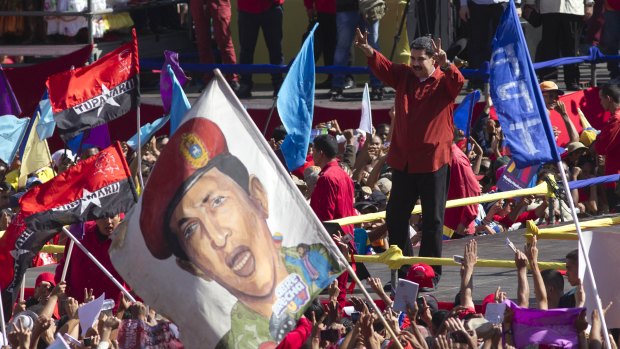 Venezuelan President Nicolas Maduro flashes victory signs after confirming he will run again.
