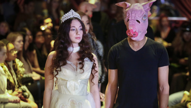 Sabrina Piper, 21, left, stands handcuffed to a male model costumed as a pig, during the #MeToo fashion show.