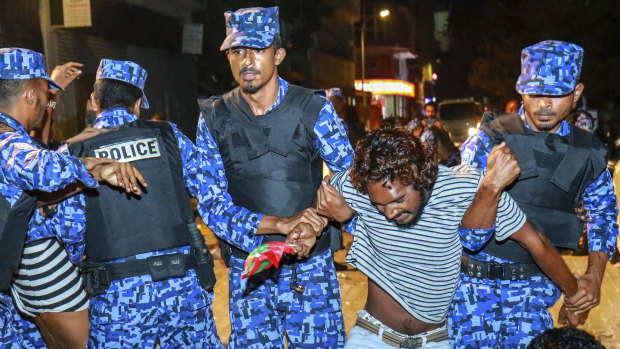 Maldivian police officers detain an opposition protester demanding the release of political prisoners during a protest in Male, Maldives.