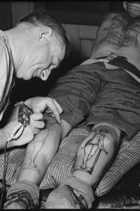 A man, believed to have been John Hennington, has the backs of his legs tattooed by Fred Harris on December 20, 1937.