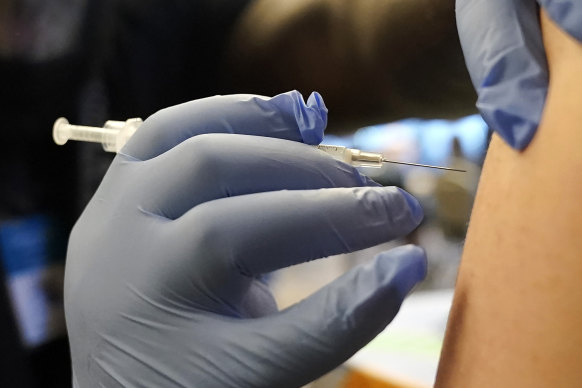 A person receives a COVID-19 vaccine booster shot.