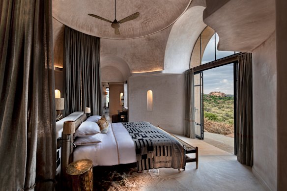 O quarto com cortinas mosquiteiras do chão ao teto que criam um santuário circular.