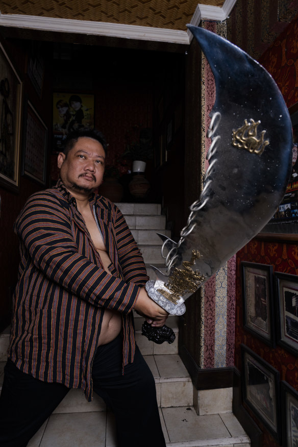 Kusomo, who is also a martial arts enthusiast, shows off an item from his sword collection.