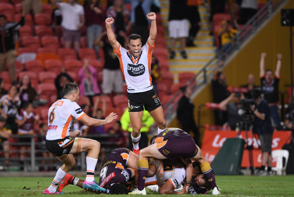 Bronco buster: Luke Brooks jumps for joy as Michael Chee Kam scores his match-winning try.