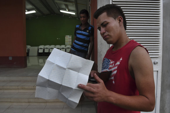 Ernesto, holding his ID papers, and friend Julio at Casa del Migrante in Flores. The pair escaped gang violence in Honduras. 