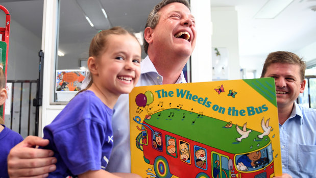 Five-year-old Lillian Mesic sits on Queensland Opposition Leader Tim Nicholls' lap as he visits a preschool in Woodhill. 