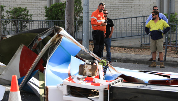 Workers survey the damage to a crane that tipped in Mitchelton, near the Brookside Shopping Centre.
