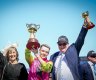 Jockey Robbie Dolan (centre) hoists the Melbourne Cup with trainers Sheila Laxon and John Symons.