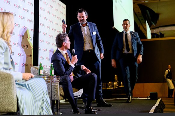 NSW Premier Chris Minns is confronted by a protester at the CEDA address on Wednesday.