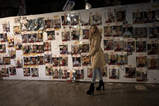 A woman visits a display of posters of people taken hostage by Hamas on October 7 last year.