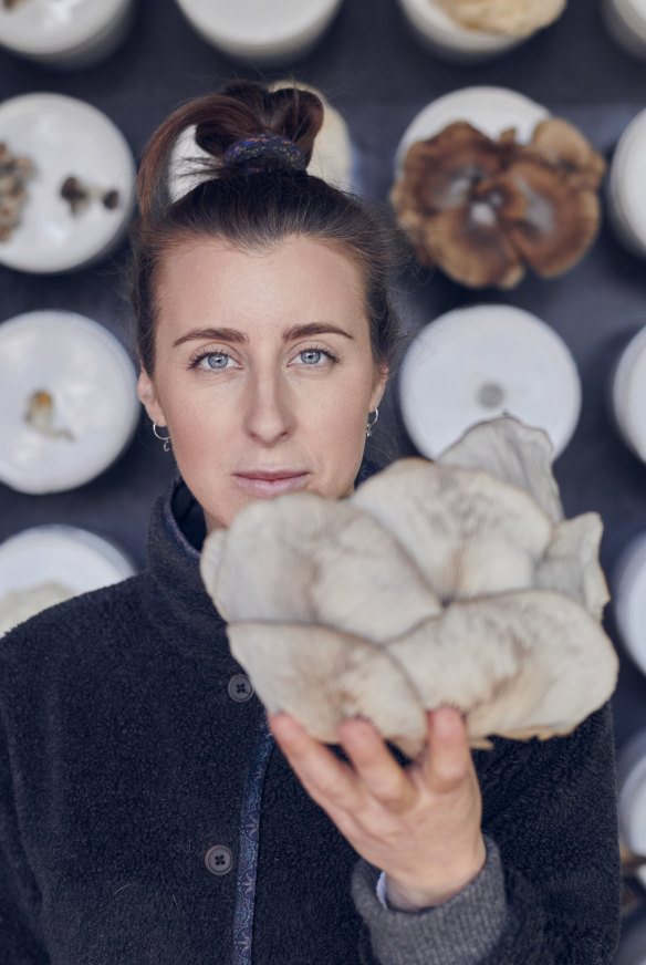 Barrett with a grey oyster mushroom grown on site at the Future Food System sustainability-showcase home in Federation Square.