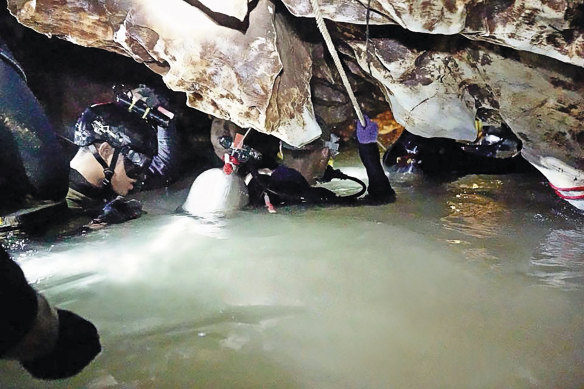 Ahead of the daring rescue, a team of divers brings supplies
and food into the cave for the boys and their coach.
