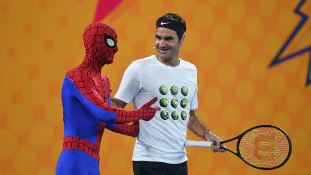 Roger Federer of Switzerland (right) is seen alongside a person dressed as Spiderman as he participates in the Rod Laver Arena Spectacular as part of Kids Tennis Day. 