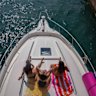 People sit on a boat as it enters Diversey Harbor on a hot and humid Tuesday, in Chicago.