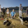 Anaru August with dog Baxter and other Caulfield dog-walking locals concerned about what Melbourne Football Club’s shift to the racecourse will mean for public use.