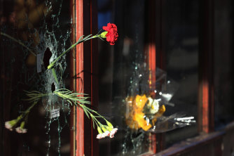 Flowers inside bullet holes in the window of Le Carillon restaurant, where the Paris terrorist attacks of November 2015 began to unfold. 