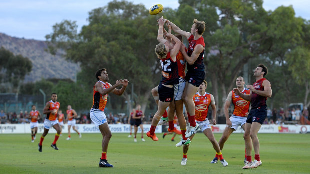 The Demons battle it out with the Suns in Alice Springs last year.