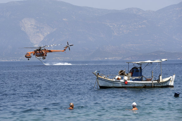 A helicopter fills up with water from the sea. 