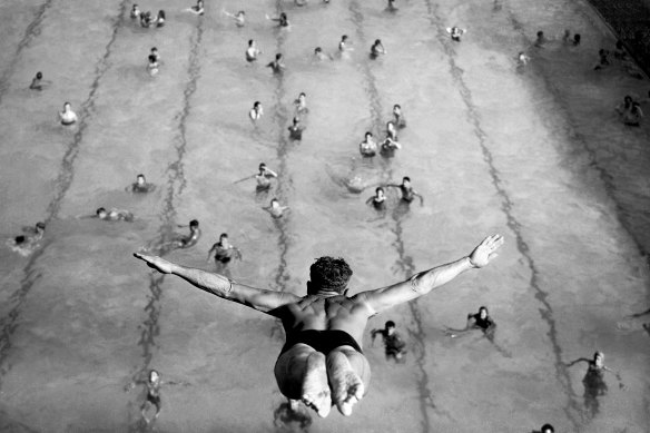 Swimmers watch as a diver launches himself from the diving tower at North Sydney Olympic Pool in January 1946.