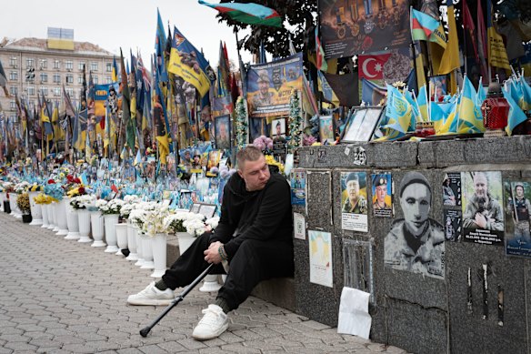 A veteran pays his respects at a makeshift memorial to Ukrainian soldiers killed in the war with Russia, on Independence Square in Kyiv.