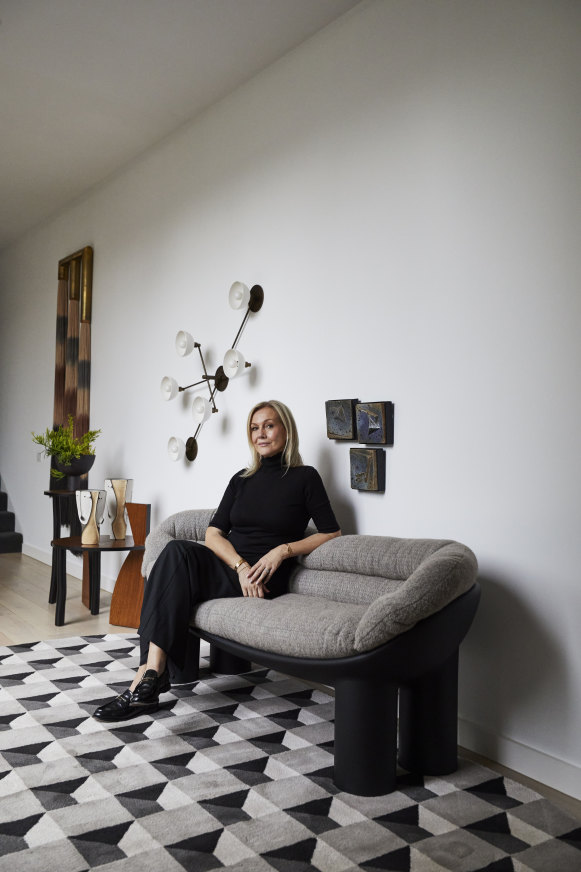 In the striking entry space, a custom wall sculpture by Lauren Williams and an 
aged brass light from Apparatus Studio flank two Frédéric Pellenq side tables.