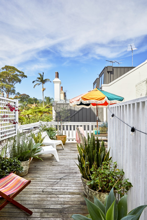 “The deck is our backyard,”  says Cynthia. “I feel like I’m in Mary Poppins looking over the mass of chimneys.”  The umbrella is by Business & Pleasure.