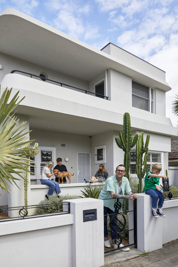 Taking cues from a curved wall in the former red-brick bungalow, the home was given a grand makeover incorporating the sleek P&O style. “It was crucial to add a second storey, as my older kids Frankie (on the porch with Caroline McCredie) and Clementine, need their own space,” says Ben Milgate, at the gate with Mac.