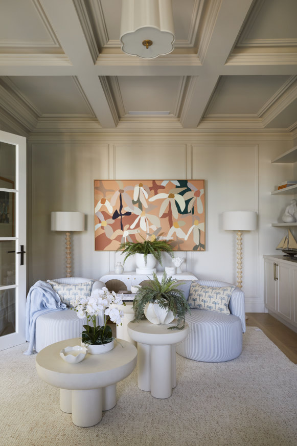 A sitting room off the hall is decorated in a palette of pale blues, with “Essay” chairs and “North Shore” coffee tables from Adairs. The artwork is by Kimmy Hogan.