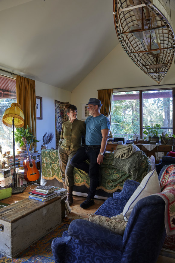 Kate Holden and Tim Flannery in the open-plan living area, where they like to entertain. It is filled with books, plants and numerous op-shop finds. Suspended above them is a wooden-framed canoe handcrafted by Peter Ingram-Jones.