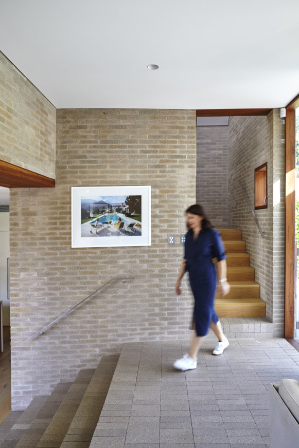 The vestibule shows the elevation of the new wing of the house and also the use of the same bricks on both floors and walls.  The framed photograph is by Slim Aarons.