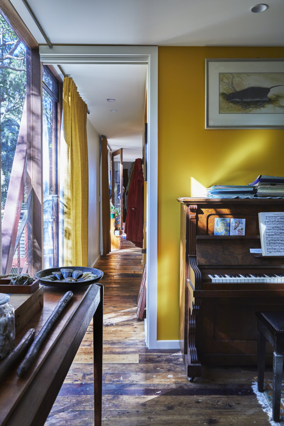 Flannery’s office looks out over a lush rainforest setting and features floorboards made from recycled Baltic pine. The print over the piano is by Peter Schouten. 