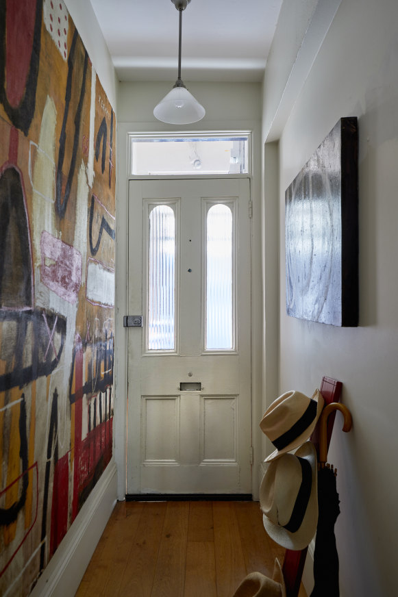 “The exterior is in original form – small but totally livable,” says Normyle. In the hall, are two paintings: a modernist oil painting on the left, and Xerxes on the right by George Raftopoulos.