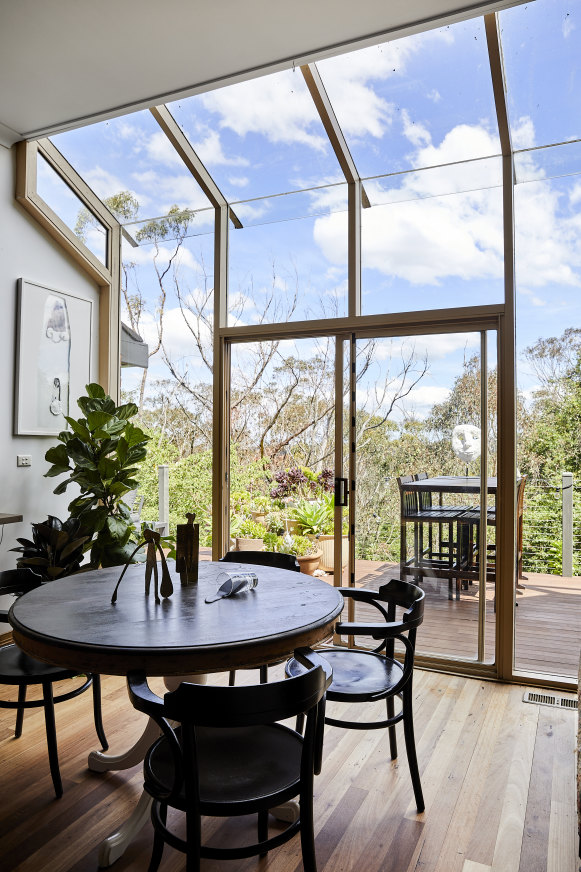 In the dining area, small bronze maquettes sit on the table, while clerestory windows flood the space with light and offer views of the surrounding bushland.