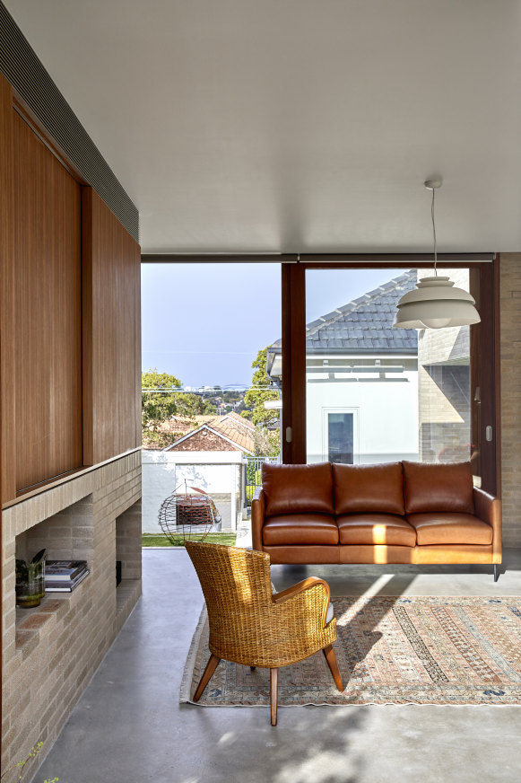 The living room overlooks the internal courtyard with a distant Harbour Bridge view. The doors enable cooling cross-breezes. Apple sculpture by Rob Bearup.