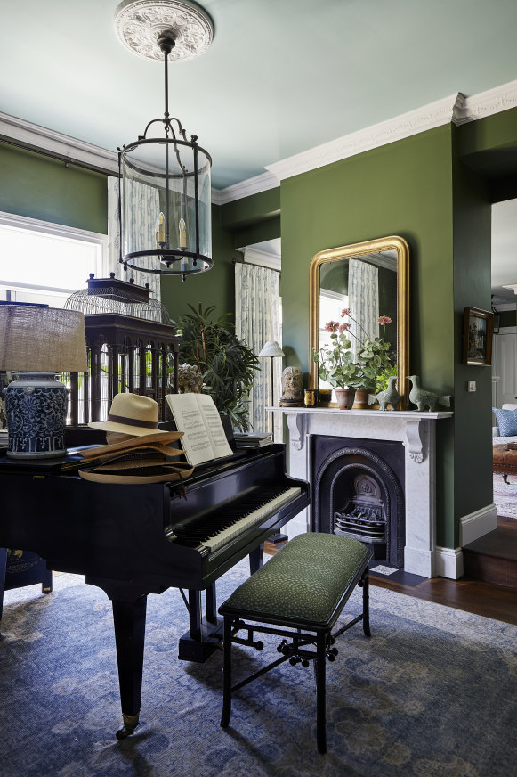 Baker had the baby grand piano she played as a child in England shipped to Australia. This room also features her collection of bird cages, plus a pendant light and vintage rug from Isla Design. 
