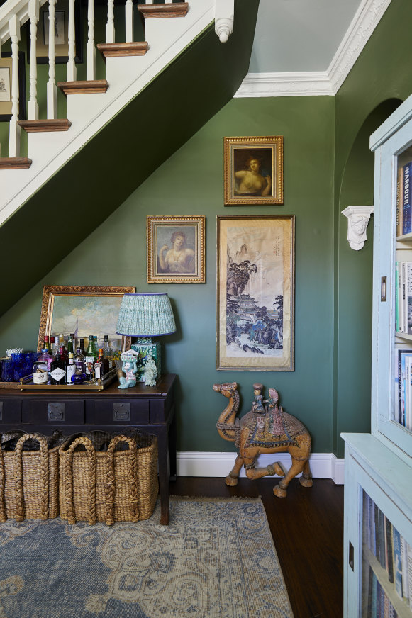 “Green Velvet” by Porter’s Paints features in the reception room. Under the  stairs, Baker has fashioned a cocktail bar from an antique Chinese console.