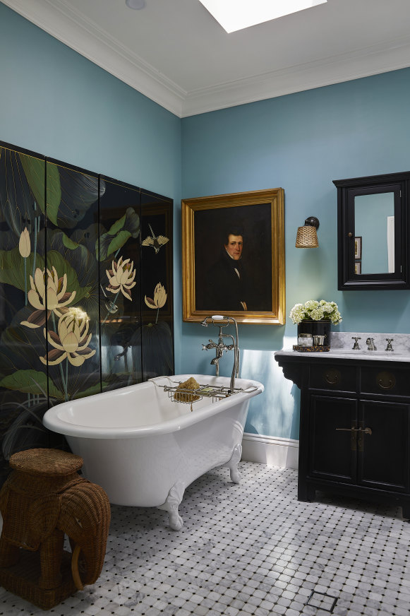 The downstairs family bathroom features a lacquered Chinese folding screen. The octagonal mosaic floor tiles are from Surface Studio.